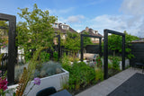 Een moderne tuin als verlengstuk van de woning-Leonardus buiten-architectonische tuin,luxe stadstuin,maatwerk plantenbakken,moderne nieuwbouwtuin,moderne pergola,moderne tuin inspiratie,rijke beplanting tuin,siergrassen tuin,tuin,tuin met meerdere zitplekken,zwarte pergola tuin-Moderne nieuwbouwtuin met pergola en beplanting-OBLY