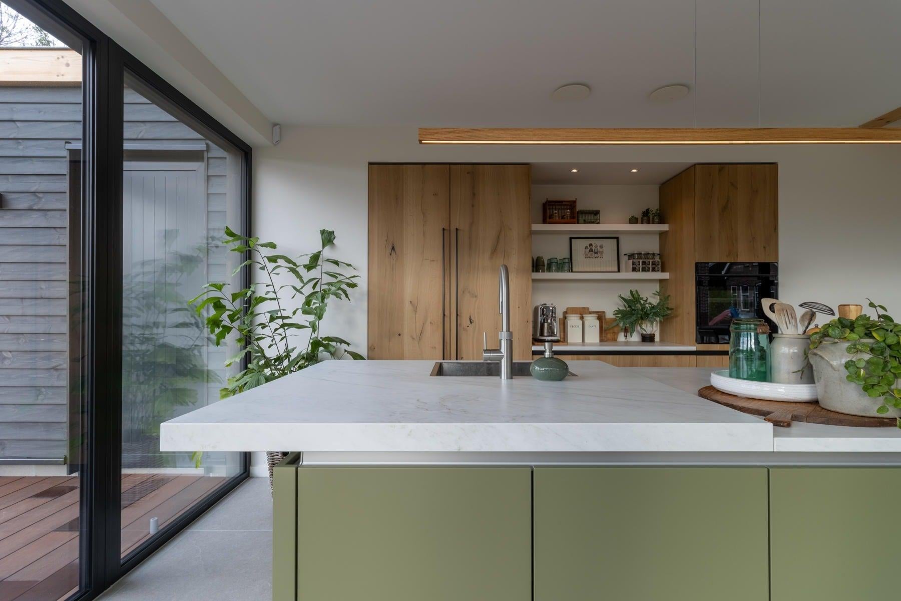 Groene keuken in een lichte en natuurlijke setting-Iemms keukens & interieur-design keuken,groene keuken,Keuken,keuken met keramisch werkblad,moderne woonkeuken-Groene keuken met kookeiland en houten kastenwand-OBLY