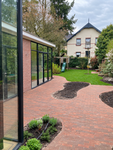 Groene stadstuin met gebogen klinkerpaden en glazen aanbouw-Pien de Bel-glazen aanbouw,groene tuin,klinkerpaden,stadstuin,Tuinontwerp-Groene stadstuin met klinkerpaden en glazen aanbouw-OBLY