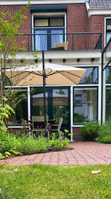Groene stadstuin met gebogen klinkerpaden en glazen aanbouw-Pien de Bel-glazen aanbouw,groene tuin,klinkerpaden,stadstuin,Tuinontwerp-Groene stadstuin met klinkerpaden en glazen aanbouw-OBLY