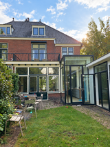 Groene stadstuin met gebogen klinkerpaden en glazen aanbouw-Pien de Bel-glazen aanbouw,groene tuin,klinkerpaden,stadstuin,Tuinontwerp-Groene stadstuin met klinkerpaden en glazen aanbouw-OBLY