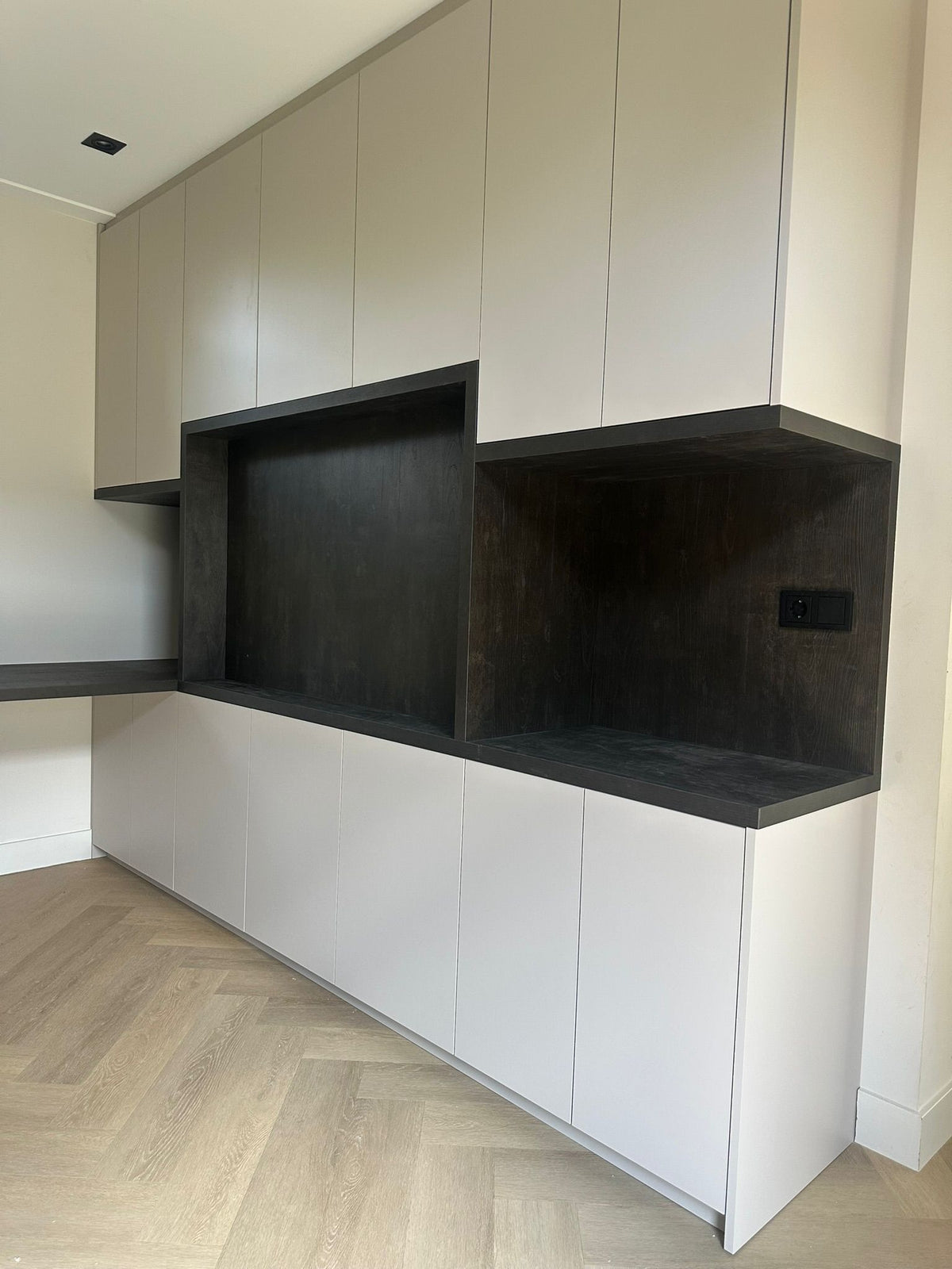 Moderne maatwerkkast met tv-meubel en nis in zwart decor-JJ interieurs-greeploze-kast,interieurmaatwerk,luxe-interieur,maatwerkkast,moderne-woonkamer,opbergruimte-op-maat,tv-meubel-op-maat,wandkast-op-maat-Moderne maatwerkkast met tv-meubel en zwarte nis-OBLY