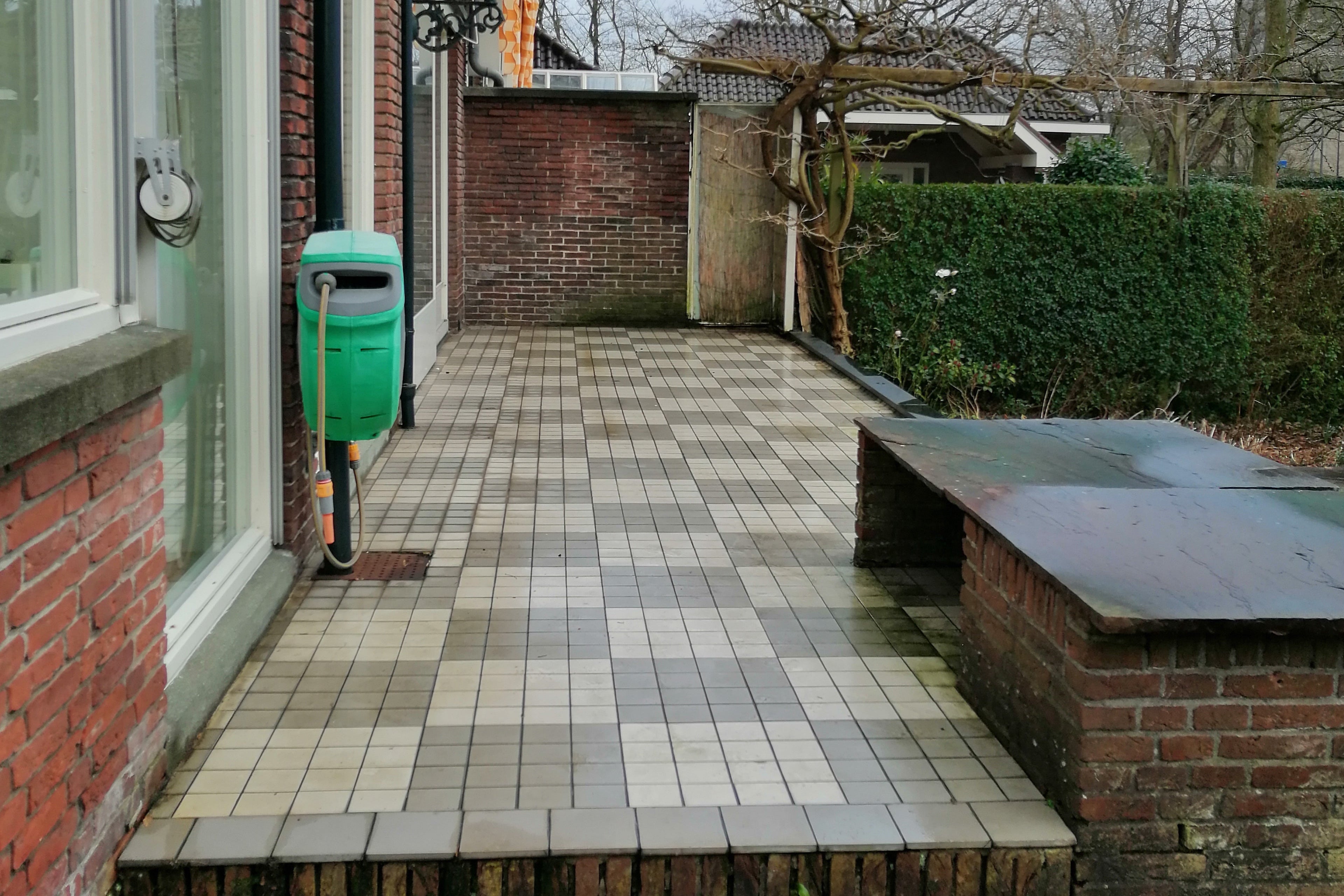 Before-foto van het terras en de achtertuin van een karakteristieke jaren '30 woning.