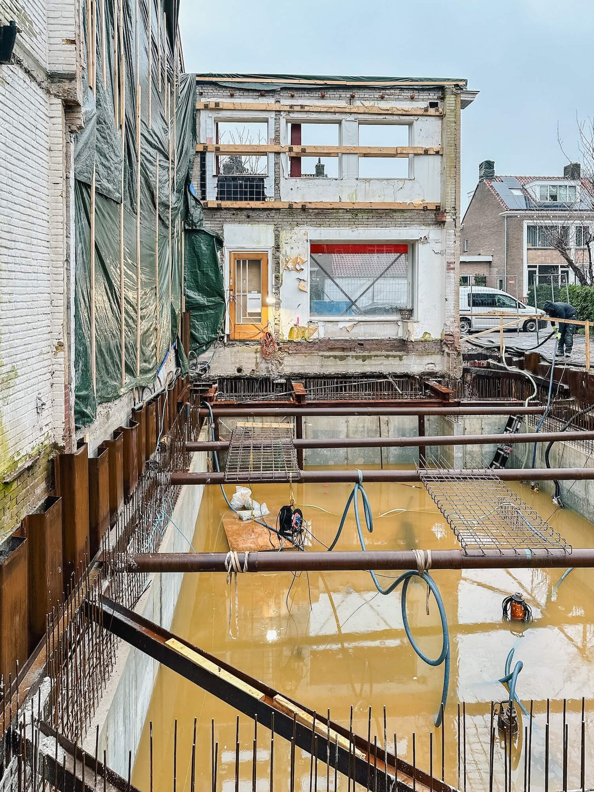 Bouwput voor het nieuwe souterrain met de behouden voorgevel op de achtergrond in de Prinses Irenebuurt