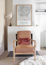 Klassieke fauteuil met kunst en warme texturen binnen het interieurontwerp van een woning in Heemstede.