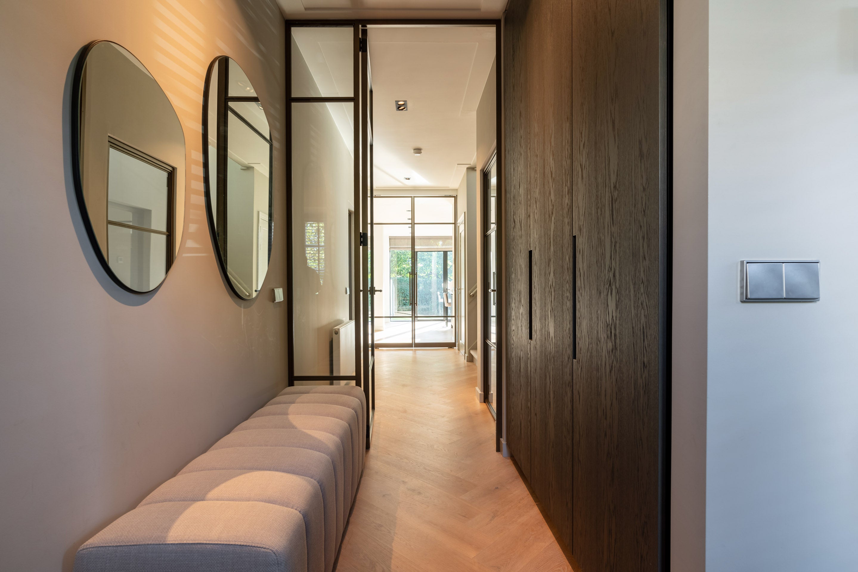 Maatwerk garderobekast en lange zichtlijn vanuit de hal naar de leefkeuken in een totaal gerenoveerde jaren '30 woning.