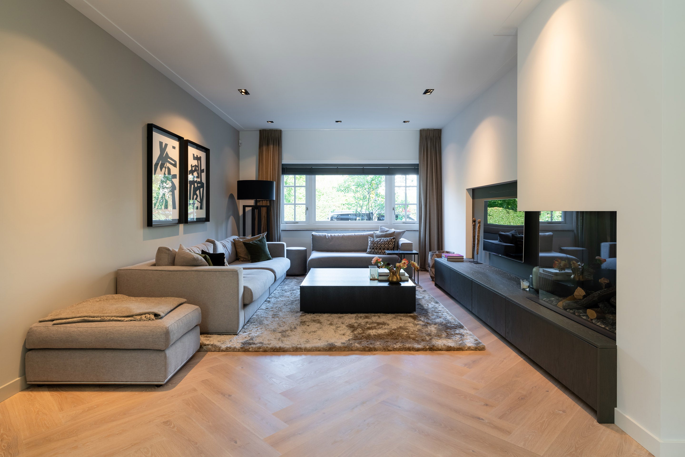 Moderne woonkamer waarin de oorspronkelijke indeling van de karakteristieke jaren '30 woning behouden is gebleven.