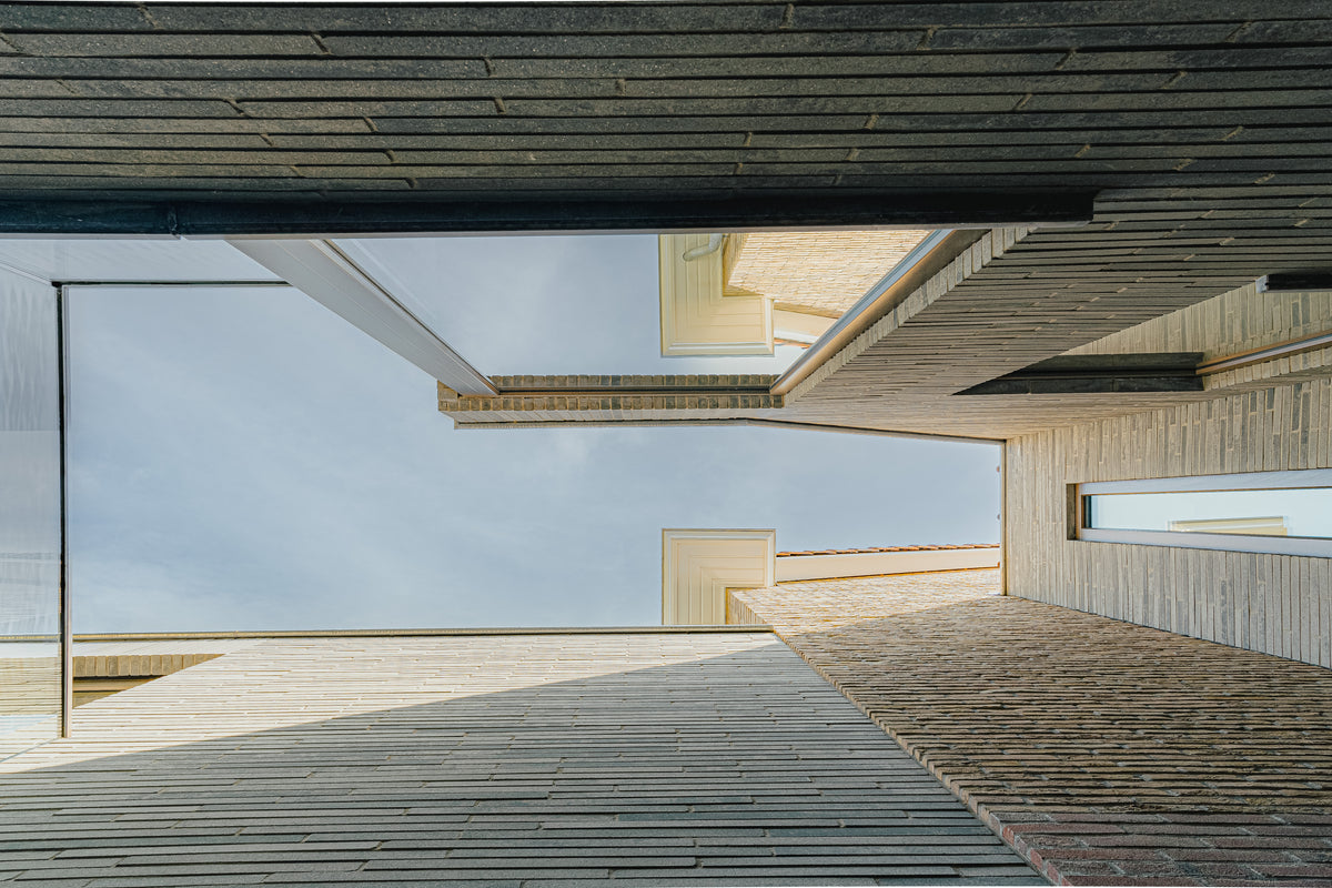 Zicht op de lucht vanuit een patio tussen hoge bakstenen gevels