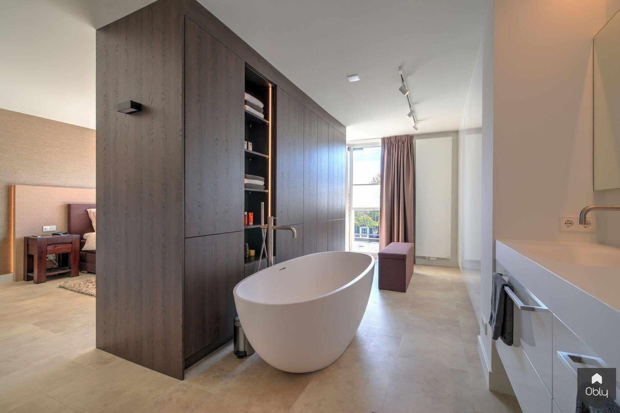 Luxe slaapkamer en aangrenzende badkamer-Dosis Keuken & Interieur-alle,ensuite badkamer,houten wandpanelen,luxe slaapkamer,moderne badkamer,sfeervolle badkamer,Slaapkamer,villa interieur,vrijstaand bad,warme woonstijl-OBLY