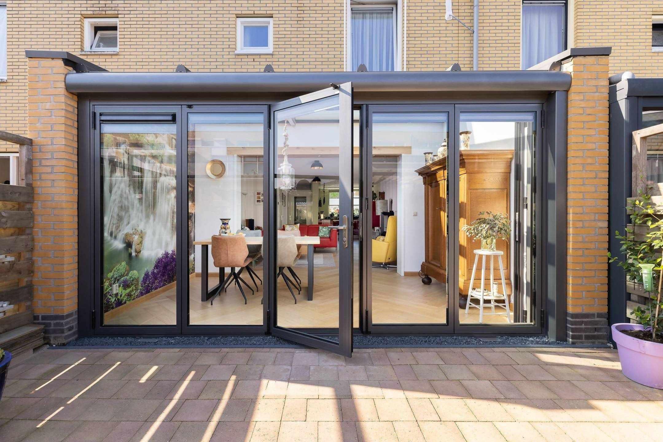 Serre aanbouw met vouwwand en lessenaarsdak-Busscher Serrebouw-Aanbouw,alle,glazen uitbouw,serre aanbouw,serre met schuifpui,serre met vouwwand,Tuinen,tuinkamer aanbouw,Woonkamer-Serre aanbouw met vouwwand en lessenaarsdak | OBLY.com-OBLY