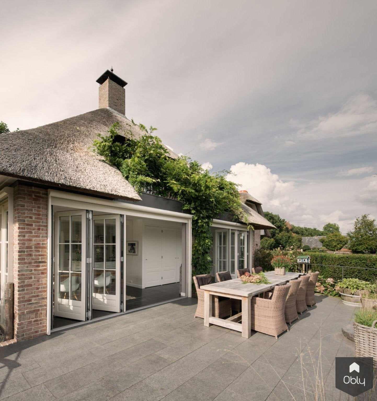 vouwwanden achterzijde villa-Solarlux Nederland BV-Aanbouw,aluminium vouwwanden,binnen buiten wonen,glazen pui,glazen vouwwanden,landelijke woning,moderne aanbouw,open leefruimte,terras met vouwwanden,vouwwanden woning,woning met glas-OBLY