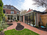 Groene stadstuin met gebogen klinkerpaden en glazen aanbouw-Pien de Bel-glazen aanbouw,groene tuin,klinkerpaden,stadstuin,Tuinontwerp-Groene stadstuin met klinkerpaden en glazen aanbouw-OBLY