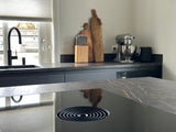 Modern interieur met zwarte keuken en warme woonruimte