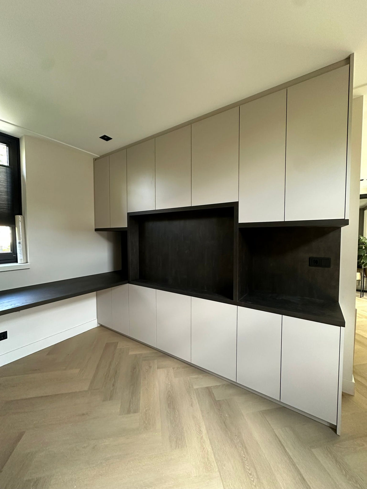 Moderne maatwerkkast met tv-meubel en nis in zwart decor-JJ interieurs-greeploze-kast,interieurmaatwerk,luxe-interieur,maatwerkkast,moderne-woonkamer,opbergruimte-op-maat,tv-meubel-op-maat,wandkast-op-maat-Moderne maatwerkkast met tv-meubel en zwarte nis-OBLY