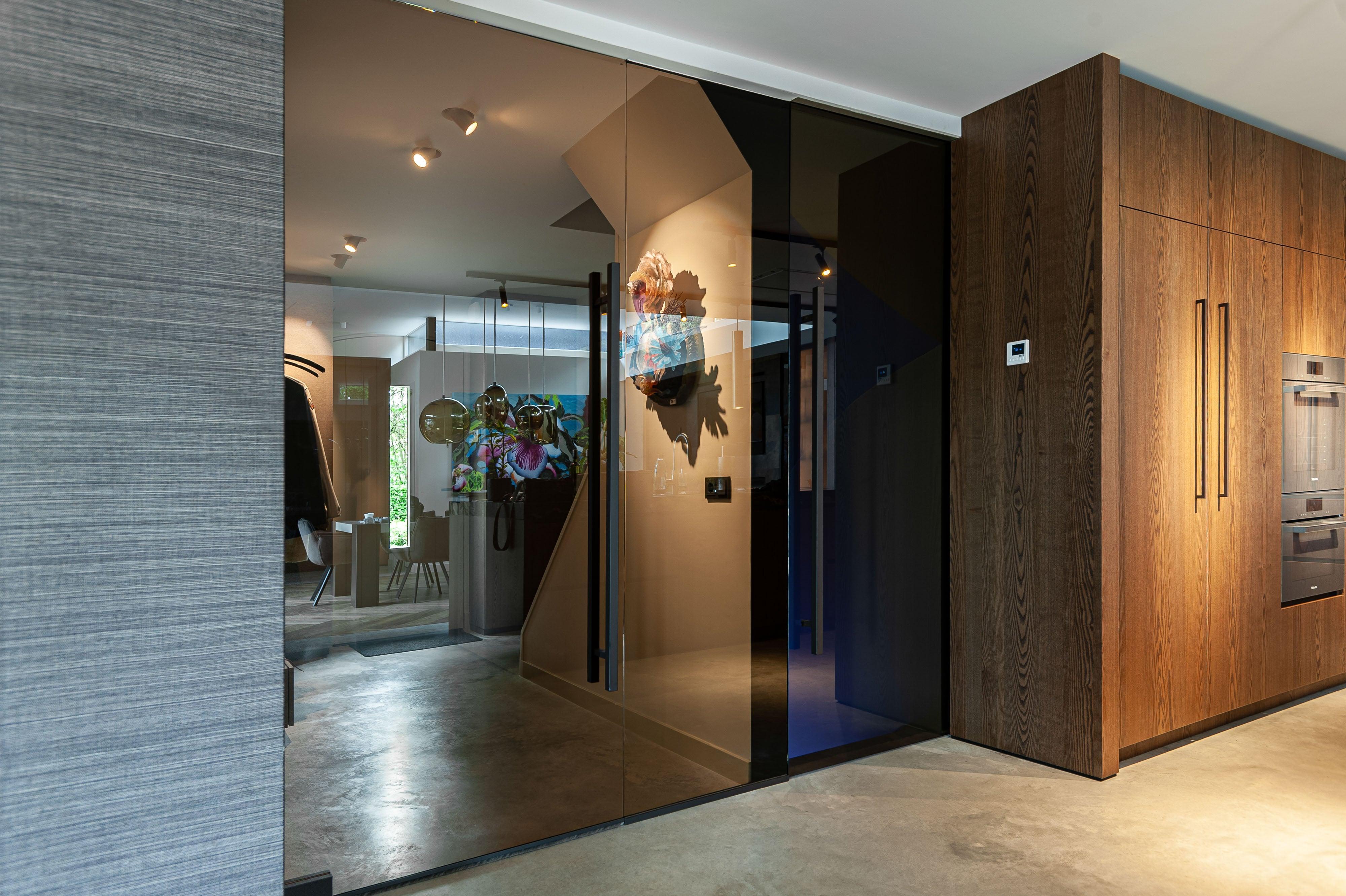 Moderne villa met naadloze binnen-buiten verbinding-Loom Architecten-architectuur op maat,binnen buiten verbinding,grote glaspartijen,luxe woning,minimalistisch design,moderne villa,open plattegrond,strakke zichtlijnen,Woonkamer-Modern interieur met open plattegrond en maatwerk design-OBLY