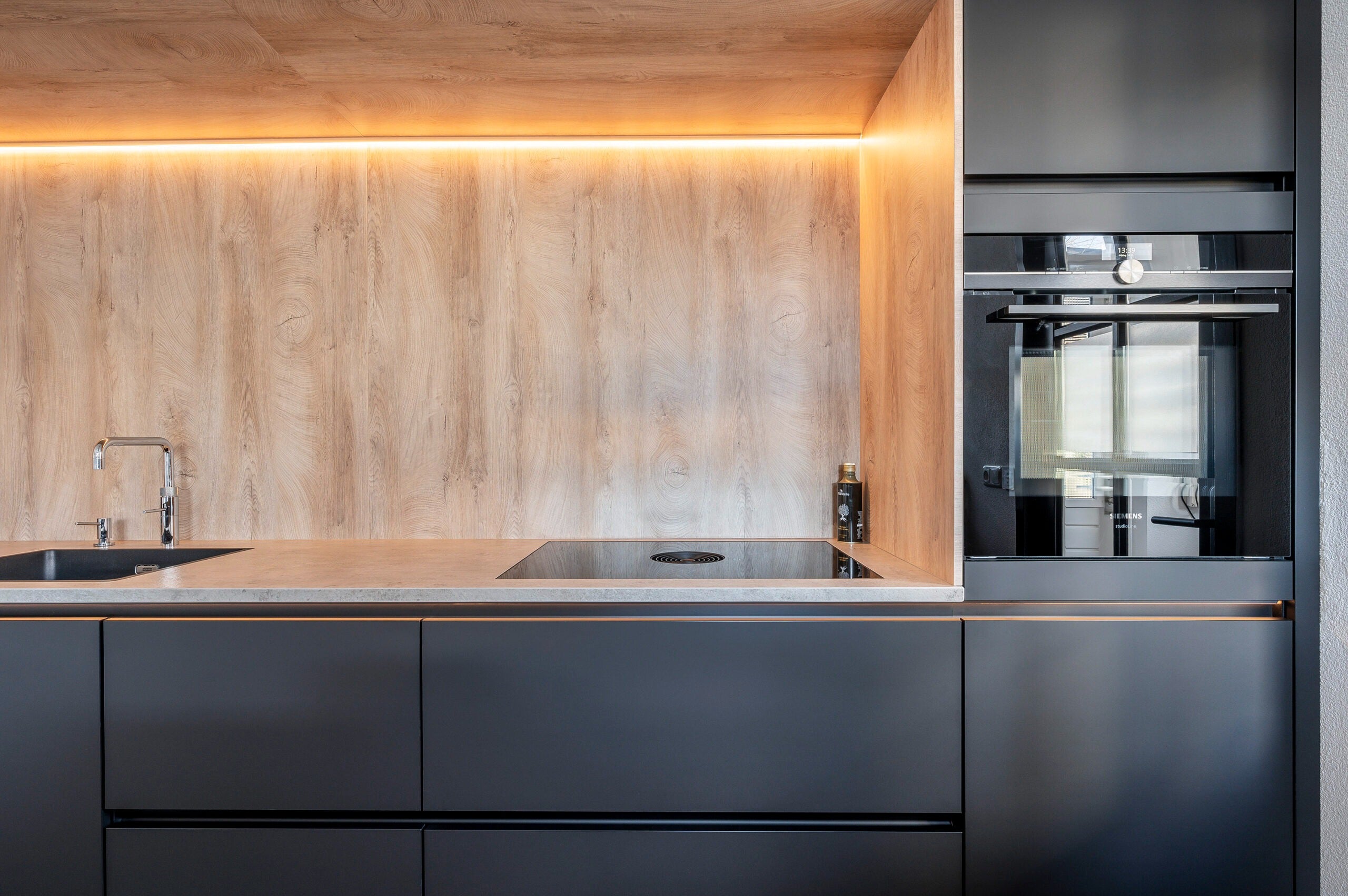 Moderne zwarte keuken met houtaccent en kookeiland-Iemms keukens & interieur-design keuken,keuken met bar,keuken met houtaccenten,luxe keuken,moderne keuken,zwarte keuken-OBLY