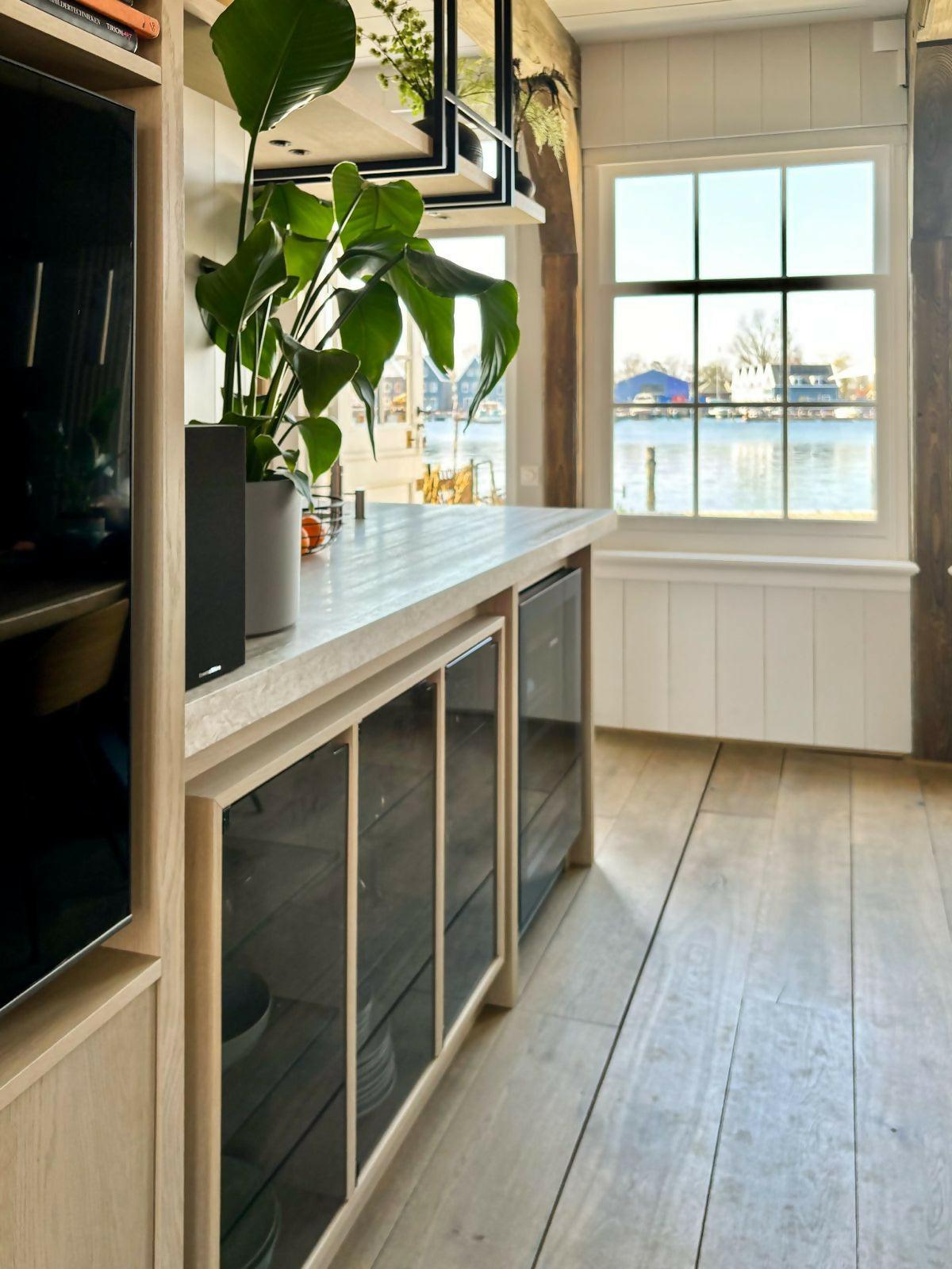 Speelse maatwerk keuken in traditionele Zaanse woning-Studio A-eikenfineer,grey oak,hout,keuken,keuken ontwerp,maatwerk keuken,marmer werkblad,moderne keuken,rvs details,speels design,stalen elementen,traditionele woning,travertin look,warme materialen,zwarte accenten-Ruim keukenontwerp in Zaanse woning Oostknollendam | Studio Å-OBLY