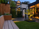 Moderne stadstuin met pergola, maatwerk hout en sfeerverlichting