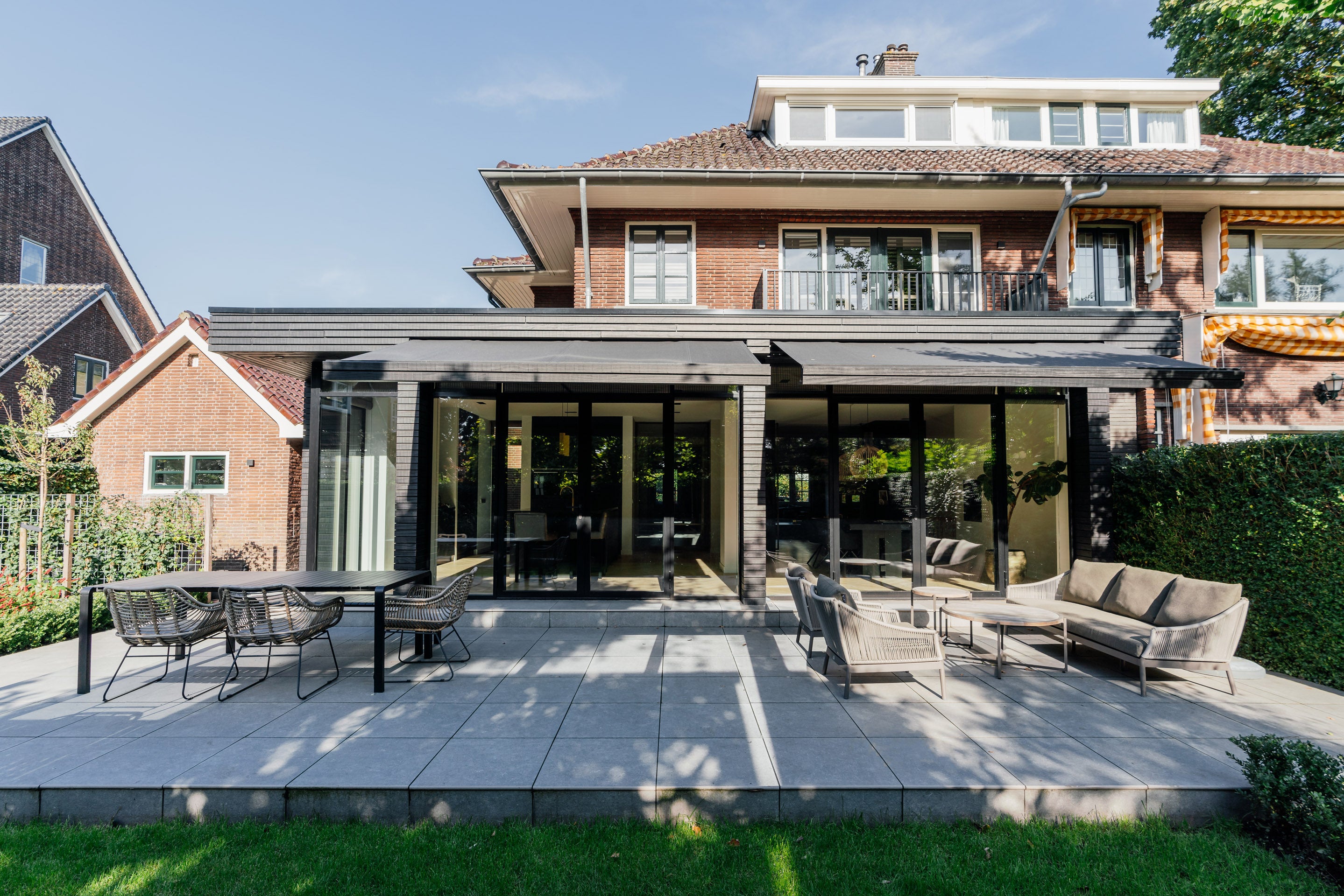 Before & After uitbouw van een jaren '30 woning met moderne aanbouw en zwarte aluminium pui.