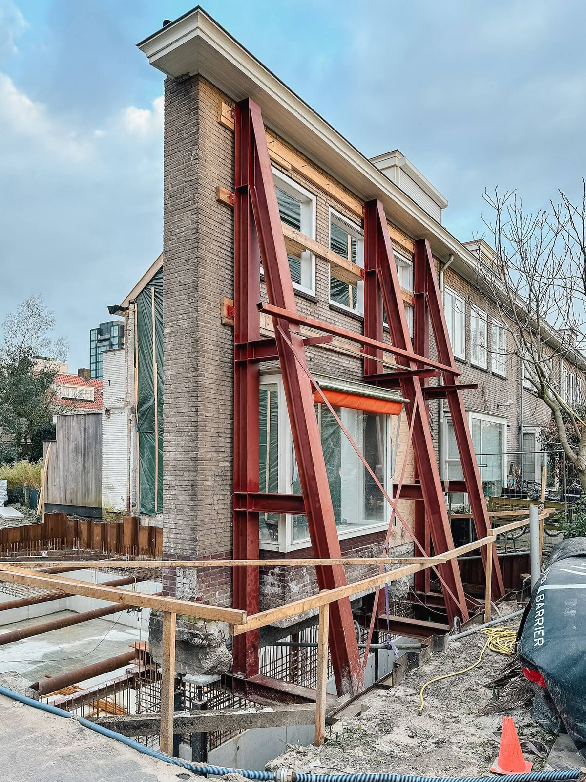 Bestaande voorgevel in de Prinses Irenebuurt met stalen stutten overeind gehouden tijdens de nieuwbouw