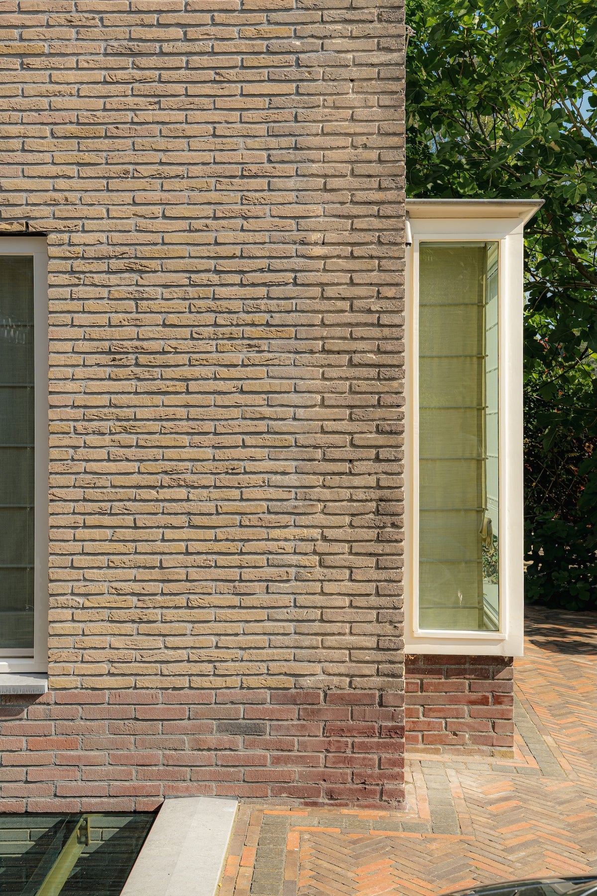 Detail van de bakstenen zijgevel met een witte erker in de Prinses Irenebuurt