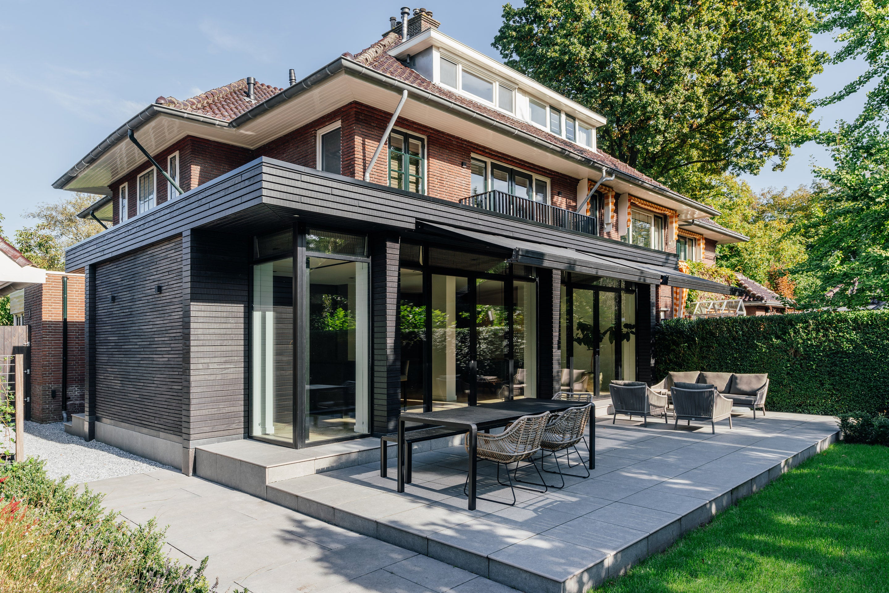 Moderne uitbreiding die naadloos aansluit op de karakteristieke architectuur van een jaren '30 woning na de totaalrenovatie.