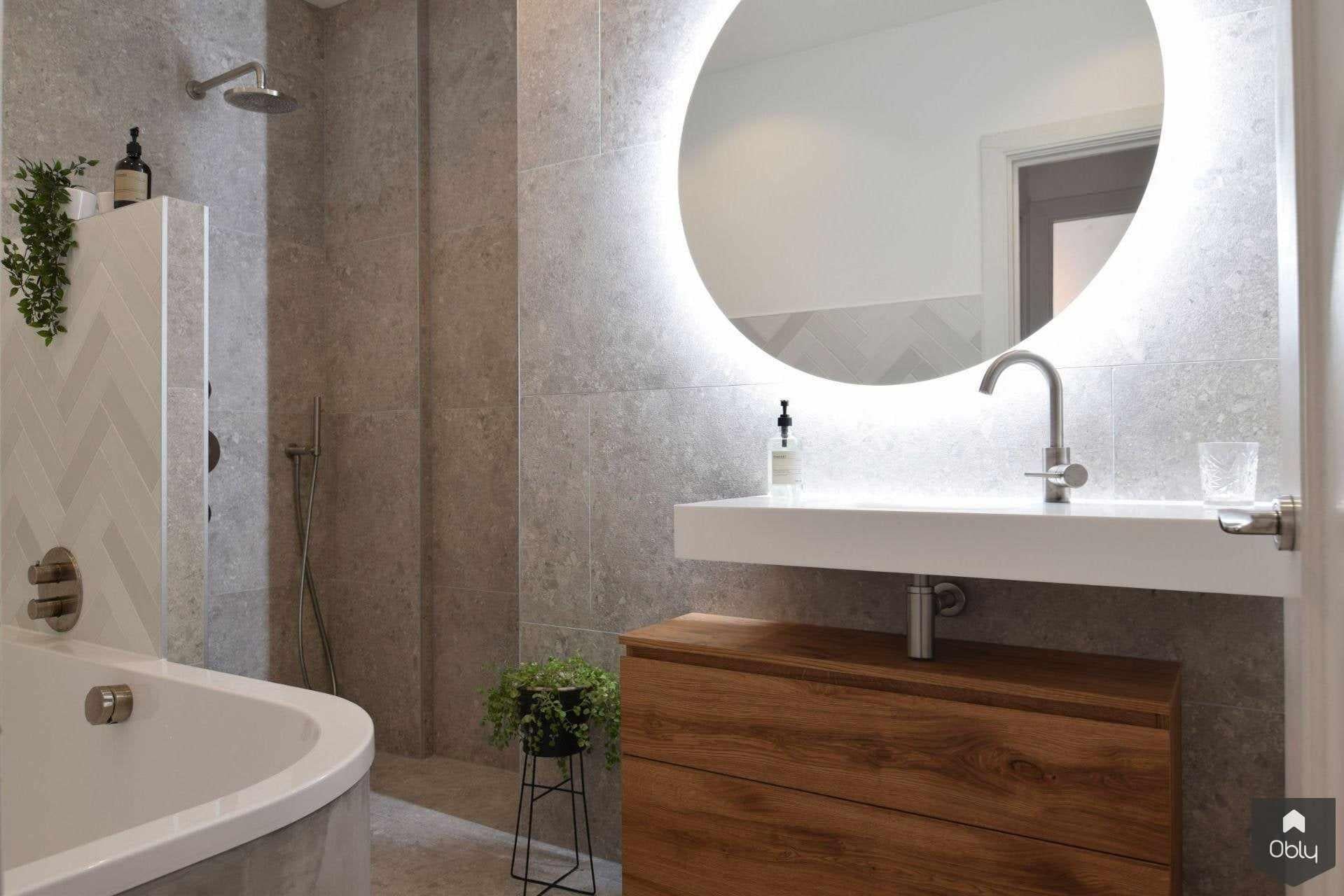 Badkamer met terrazzo tegels en visgraat motief-Studio Lieke Sanders-alle,Badkamer,badkamer design,grijstinten,houten meubel,luxe badkamer,moderne badkamer,ronde spiegel,sfeervolle verlichting,terrazzo tegels,visgraat tegel-OBLY