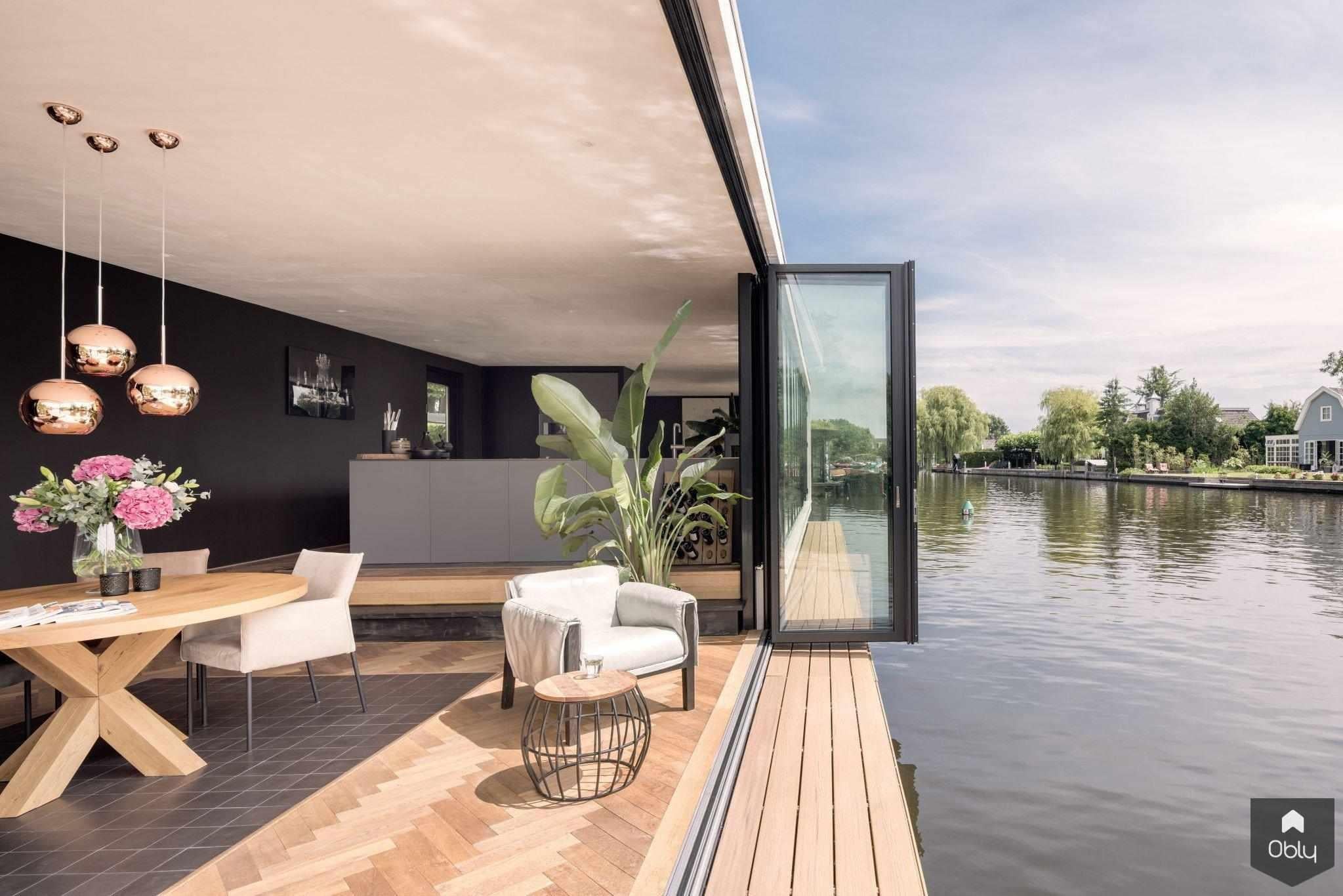 Glazen vouwwanden op een moderne woonboot-Solarlux Nederland BV-alle,aluminium vouwwanden,binnen buiten wonen,glaswand naar terras,glazen vouwwanden,luxe woonboot interieur,moderne woonboot,open woonkamer terras,panoramisch uitzicht water,wonen aan het water,woonboot renovatie,Woonkamer-OBLY