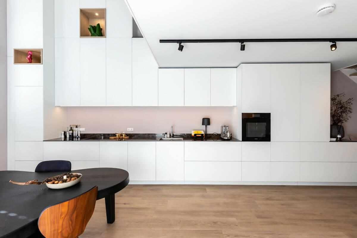 Hoge keuken verbonden met woonkamer-Huisvanbinnen-design meubels interieur,hoge keuken woonkamer,Keuken,lichte keuken inspiratie,maatwerk stalen trap,minimalistisch interieurdesign,moderne woonkeuken,open leefruimte,verbonden woonkamer keuken,witte houtlook keuken-Hoge keuken verbonden met woonkamer-OBLY